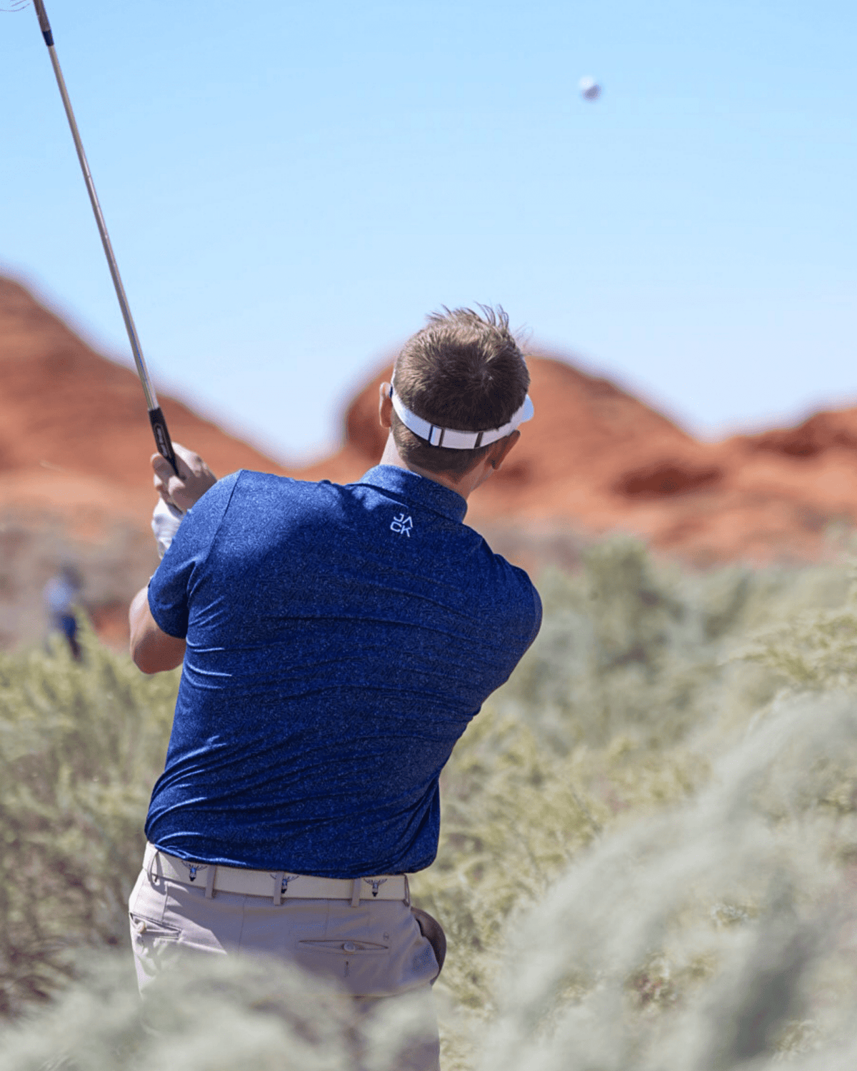 Back view of Cowboy Caddie Blue Texas golf polo showing tailored fit and lightweight performance material