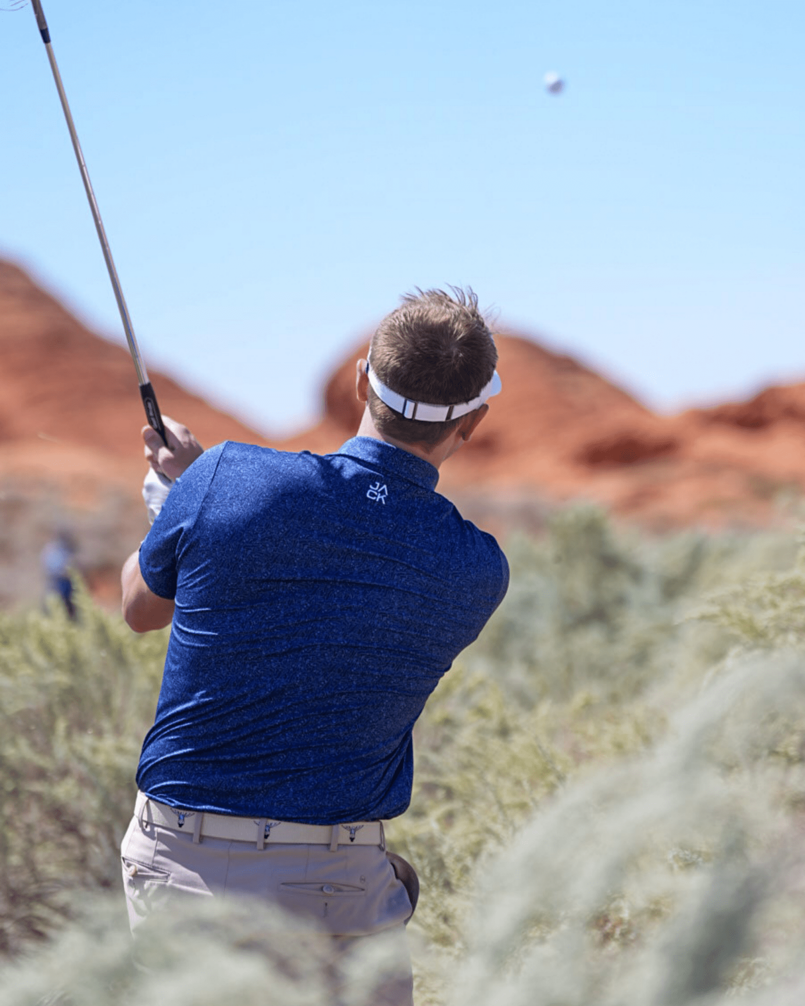 Back view of Cowboy Caddie Blue Texas golf polo showing tailored fit and lightweight performance material