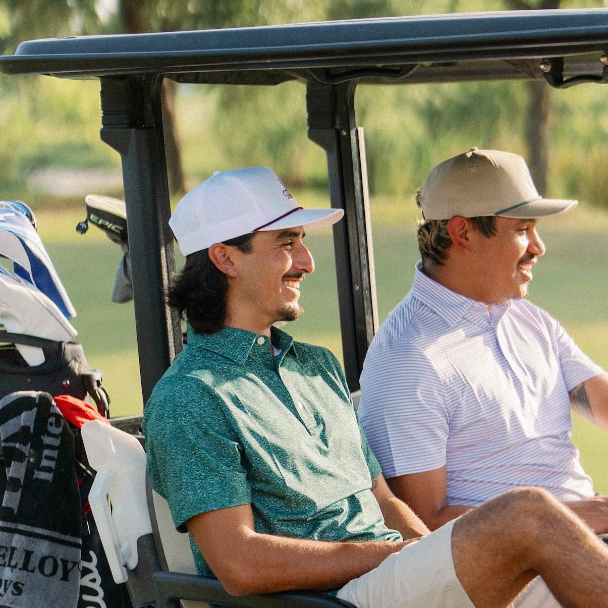 Two golfers in a cart at sunset, one wearing the Texas Bluebonnet Maroon Rope Hat